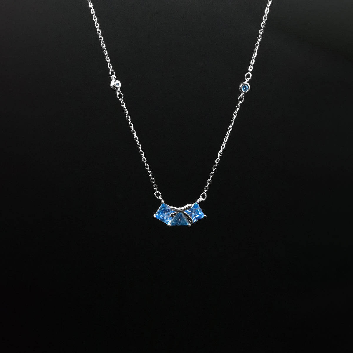 Necklace with a blue pendant on a black background
