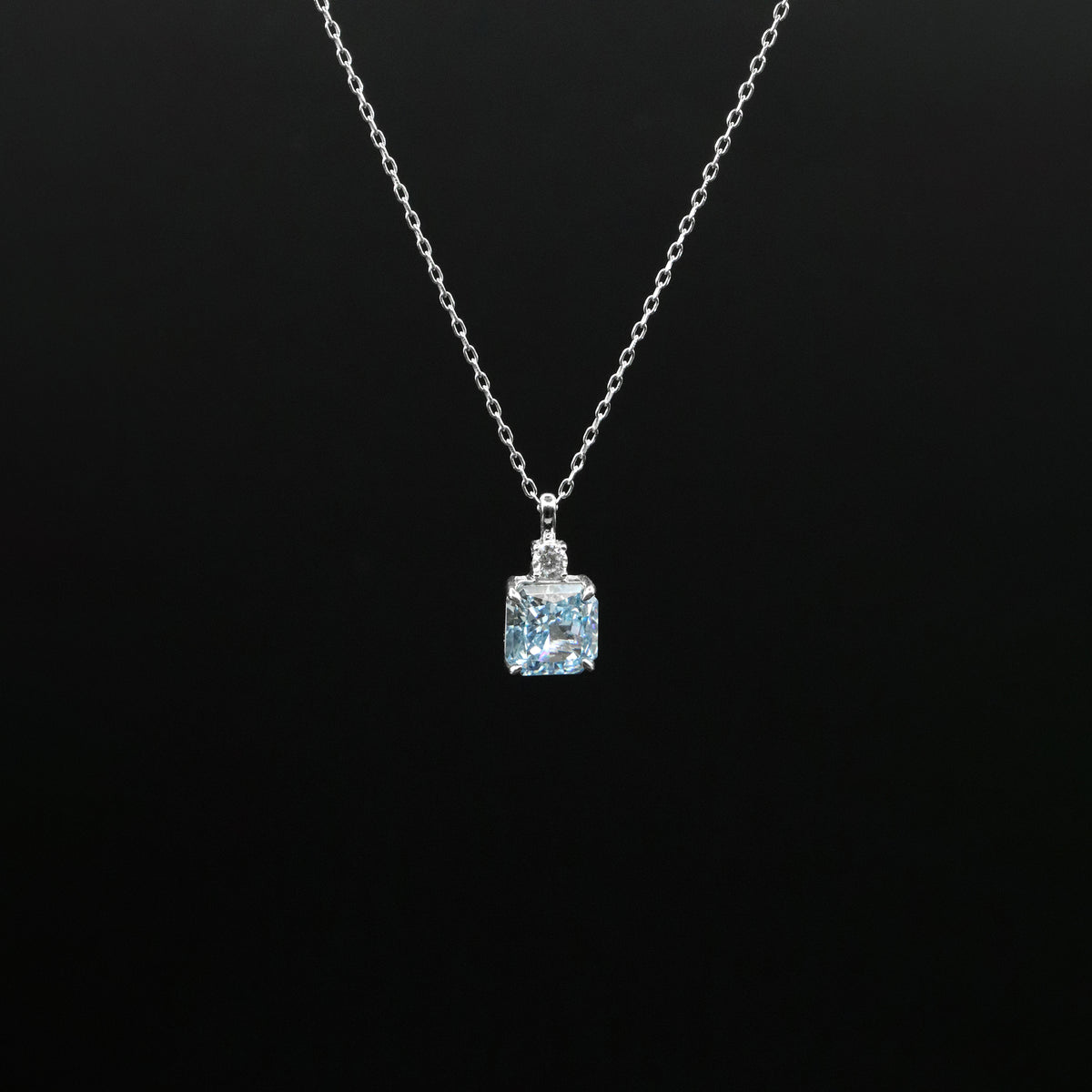 Necklace with a pendant featuring a blue gemstone on a black background