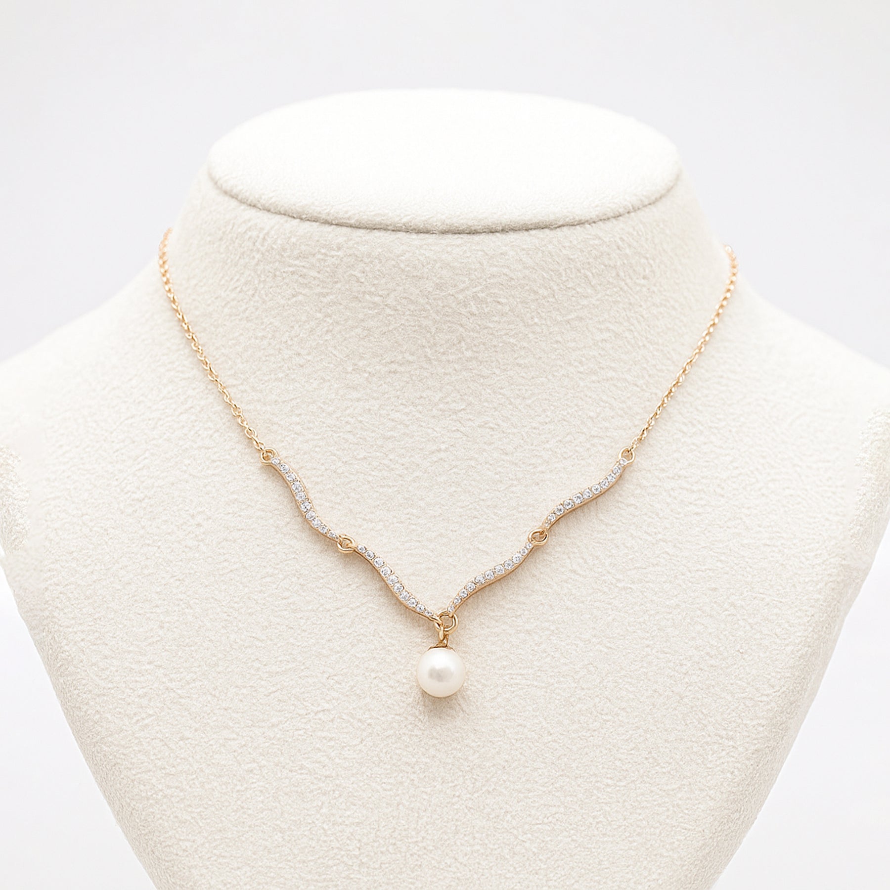 Pearl necklace on a mannequin bust with a white background