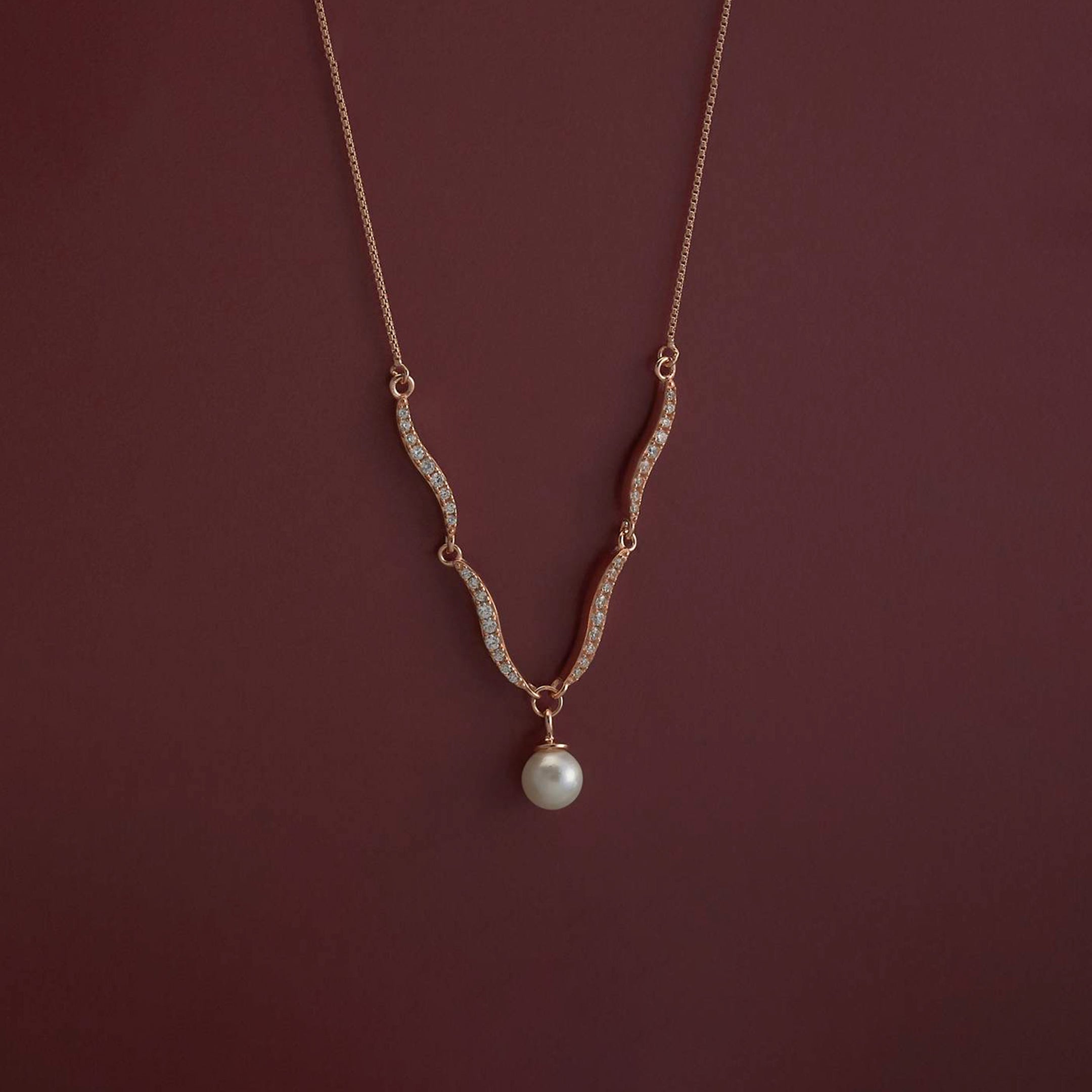 Necklace with a pearl pendant on a dark red background