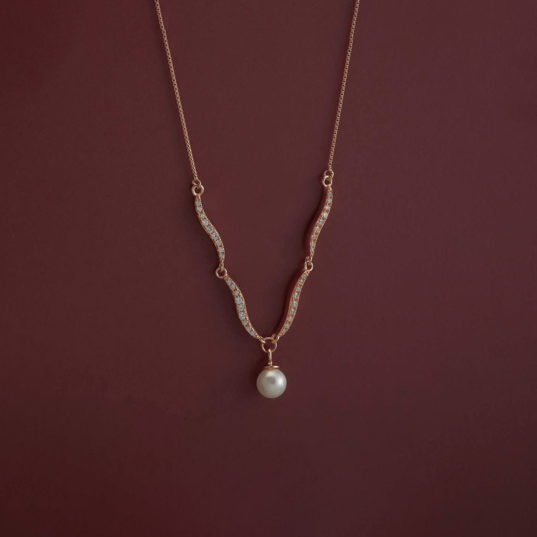 Necklace with a pearl pendant on a dark red background