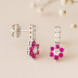 Pair of earrings with pink gemstones on a beige background