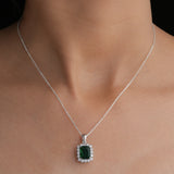 Green gemstone necklace on a person's neck with a plain background